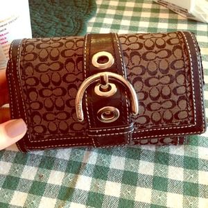 Black coach wallet with buckle front. Black coach wallet with buckle front.