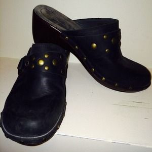 Black leather clogs with bronze rivets. Black leather clogs with bronze rivets.