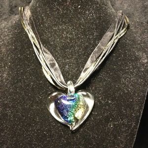 Glass heart pendant on black ribbon necklace.