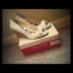 White peeptoe wedges with cute bows.