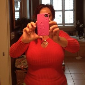 Coral sweater with silver heart attached at top.