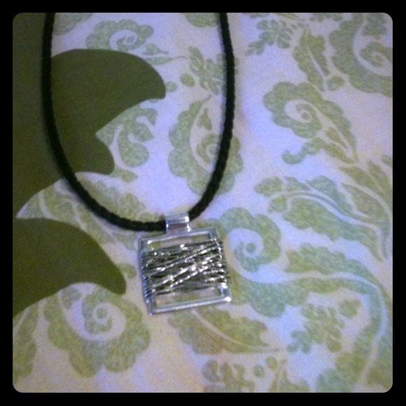 A necklace silver charm and black chain