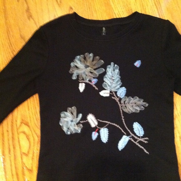 Black top with light blue flower appliqué