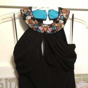 Floor length black dress with beading at collar.