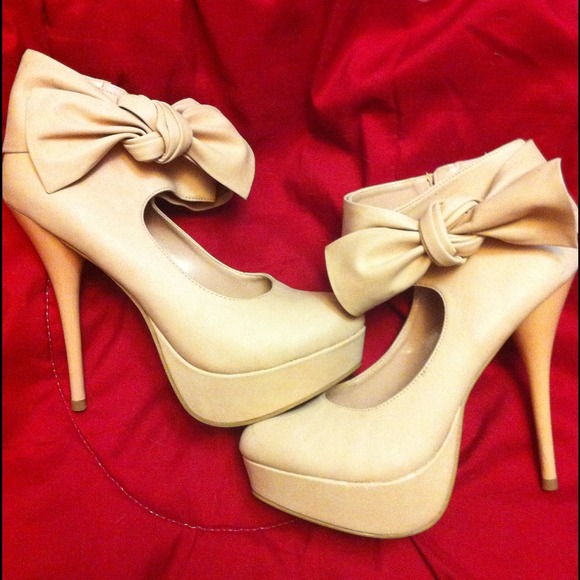 Beige pumps with ankle strap and bow.