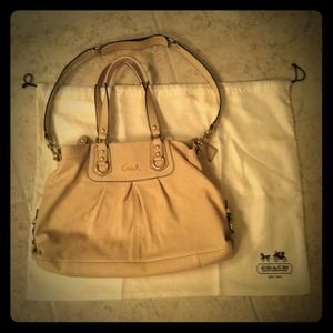 Cream colored Coach purse with gold hardware.