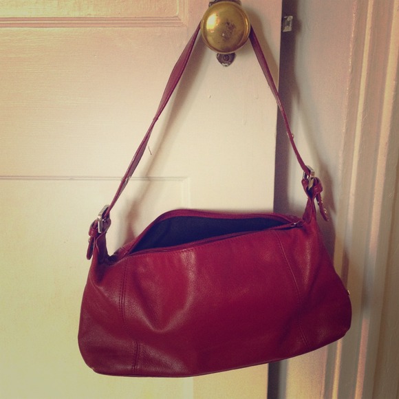 Small red purse with adjustable straps.