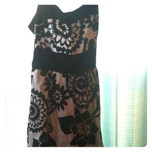 White dress with floral design and sash at waist.