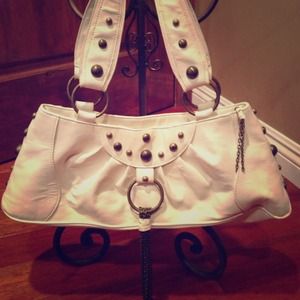 White handbag with gold studs and tassel
