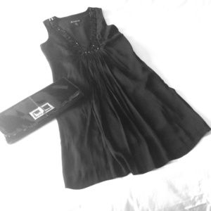 Black cocktail dress with black bread detail.
