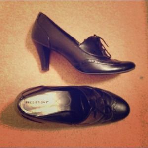 Black "Oxford" heels bundled with grey pants.