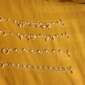 Four sterling silver plated charm bracelets.