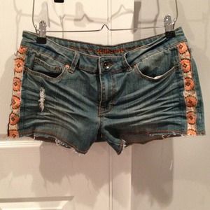 Denim shorts with orange design.