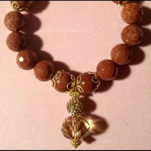 Unique goldsand bracelet with charm.