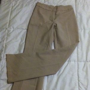 Tan dress pants, pleated down the front.
