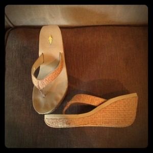 Hold Tan flip flops.