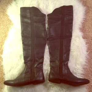 Black leather high knee flat boots.