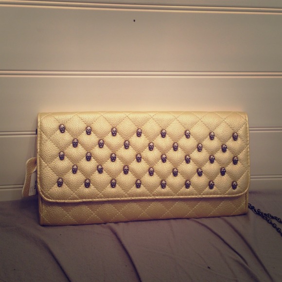 Gold quilted skull-studded clutch with chain