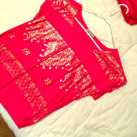 pink shirt with gold tribal print on it