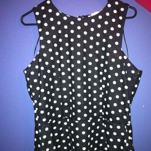 A black shirt with white polka dots that flare out