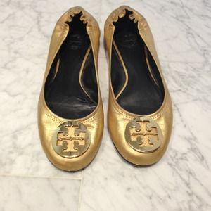 Tory Burch gold Reva flats with gold emblem.