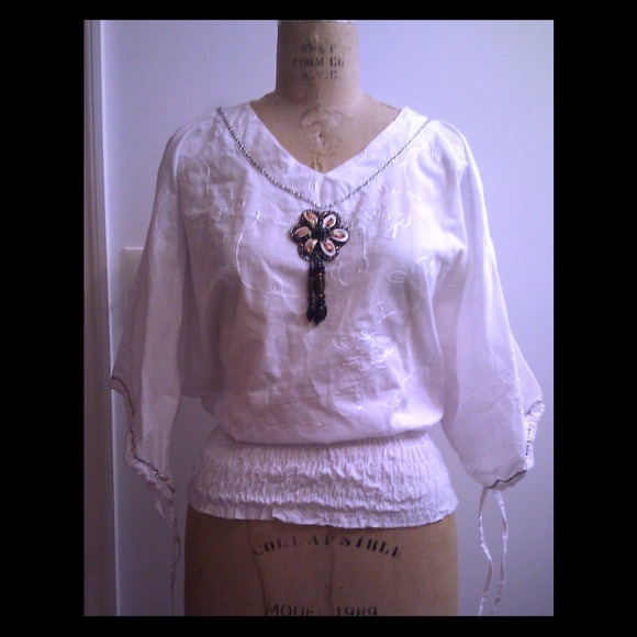 White oversized top with beaded flower. Size small