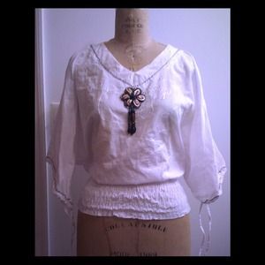 White oversized top with beaded flower. Size small