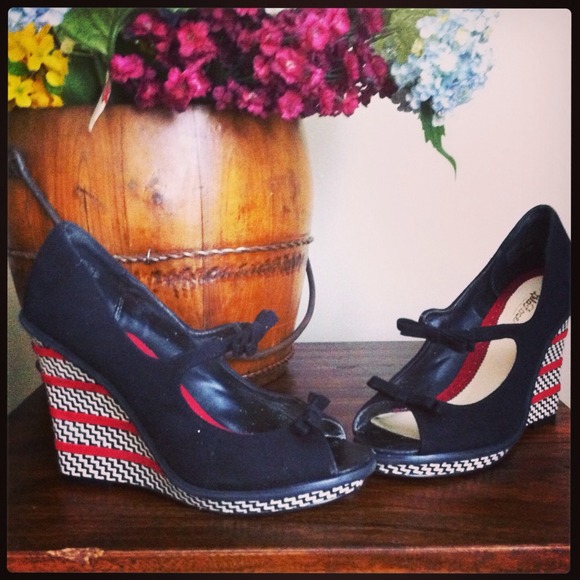 Black peep-toe wedges with bow and wedge details.