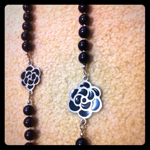 Long Black bead necklace with flower accents.