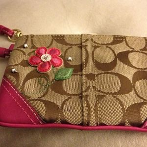 Coach wristlet with pink flower embellishment