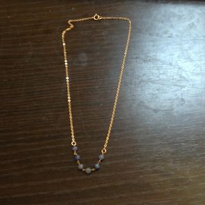 Delicate gold chain with blue beads.