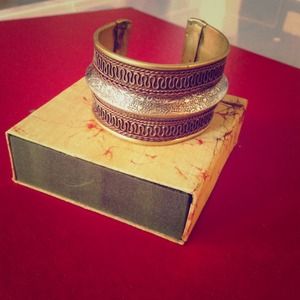 Thick metal bracelet. Adjustable to fit wrist.