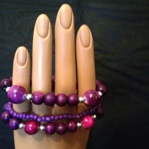 A set of three purple tone beaded bracelets
