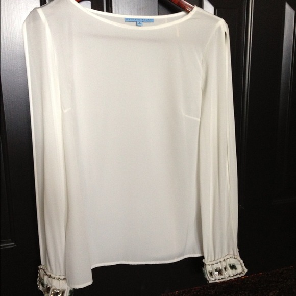 White blouse with embellished cuffs.