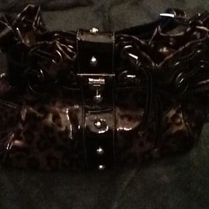 Animal print patent leather drawstring handbag.