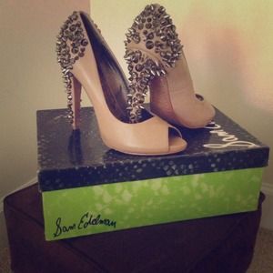 Peep toe nude color jeweled pumps.