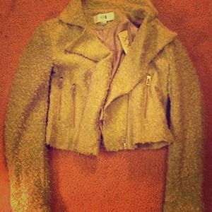 Tweed jacket with zippers on front and sleeves.