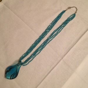 Teal glass pendant on a beaded necklace