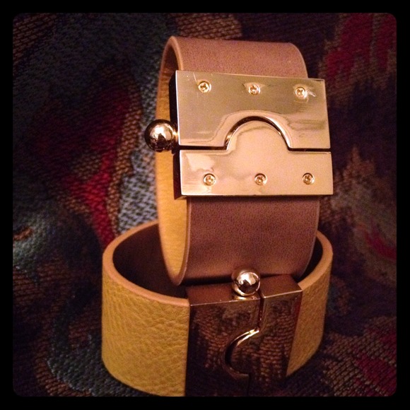 Reversible leather cuff with puzzle lock closure.