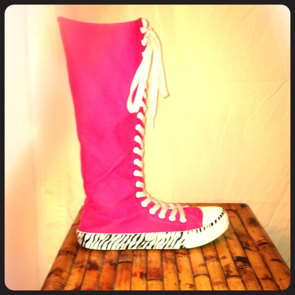 Pink high tops with zebra print on the bottom.