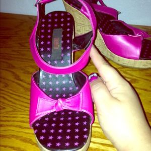 Pink wedges with bows on toes.