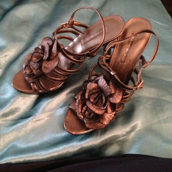 Silver high-heeled sandals with flower detail.