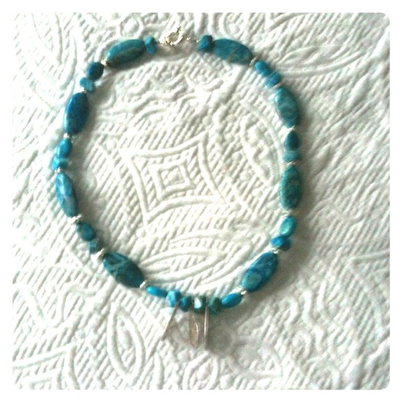 Turquoise stone necklace with silver flowers.