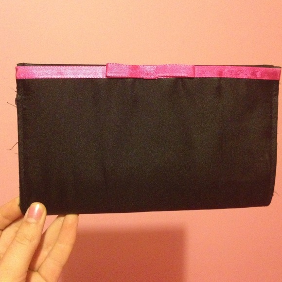 Silky black clutch with a hot pink bow