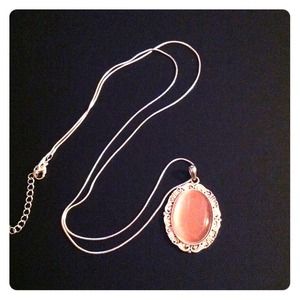 Silver chain with pink pendant.