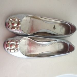 A pair of Audrey Brooke glam flats in silver.