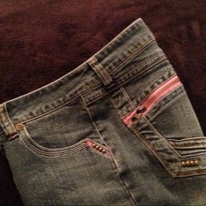 Jeans with pink zipper pockets & stud accents.