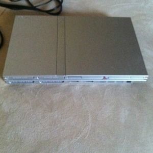 A silver ps2 with controller.