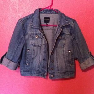 Crop jean jacket with cuffed sleeves.
