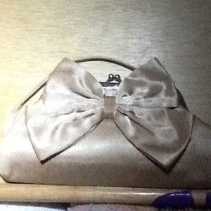A pretty golden clutch with bow detail. A pretty golden clutch with bow detail.
